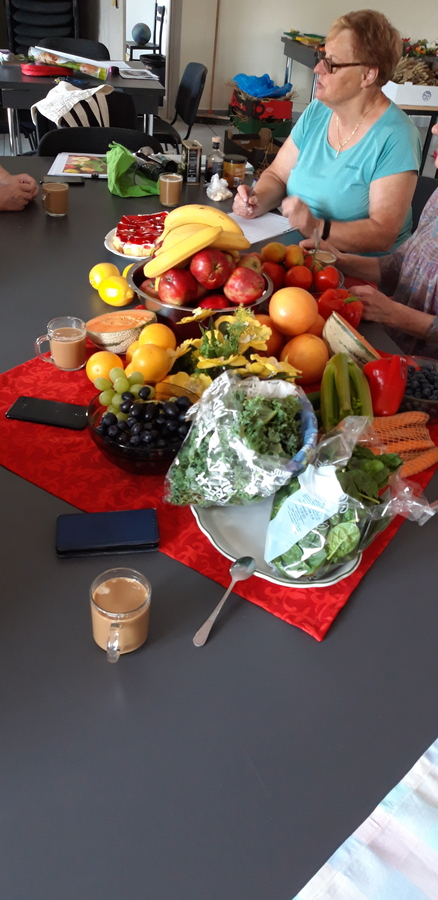uczestniczka warsztatów siedząca przy stole, a na nim warzywa i owoce
