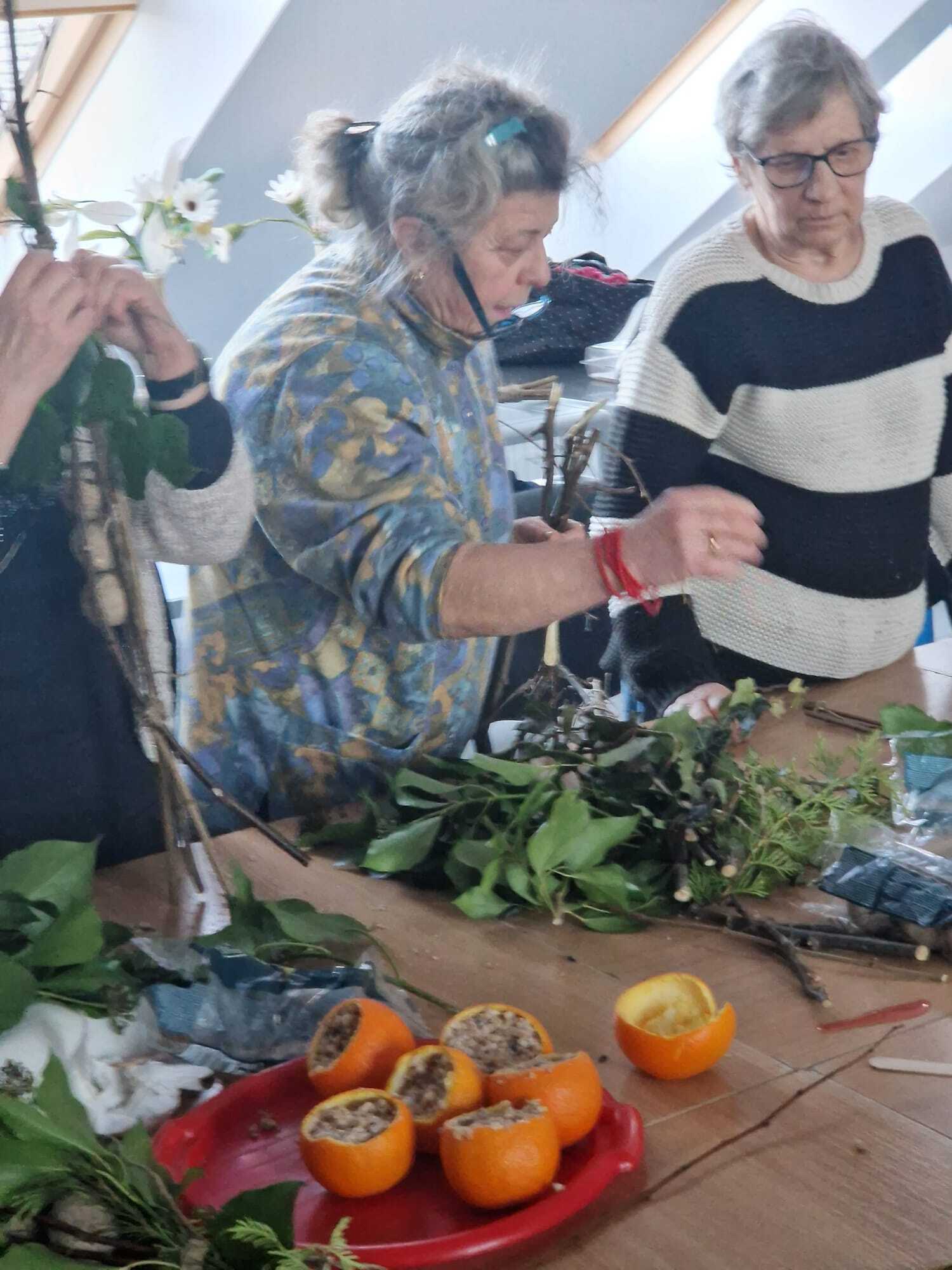 trzy uczestniczki warsztatów stojące przy wspólnym stole tworzące karmniki dla ptaków