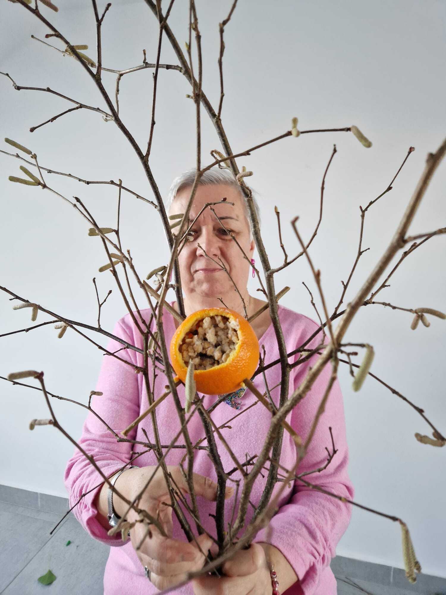 uczestniczka warsztatów z gałązkami w dłoniach tworząca karmnik dla ptaków
