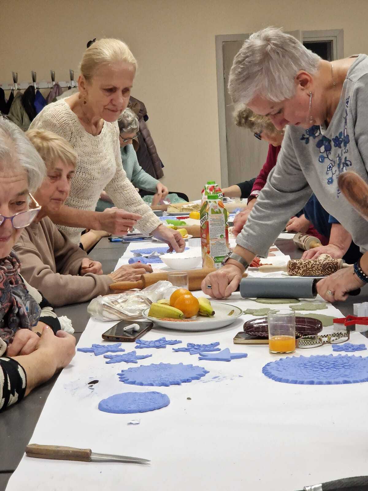 uczestniczki warsztatów przy wspólnym stole tworzące ozdoby ceramiczne