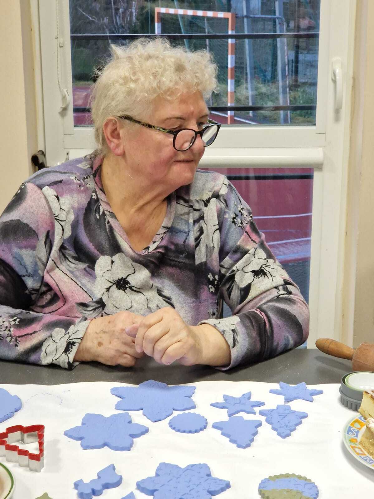 uczestniczka warsztatów przy stole tworząca ozdoby ceramiczne