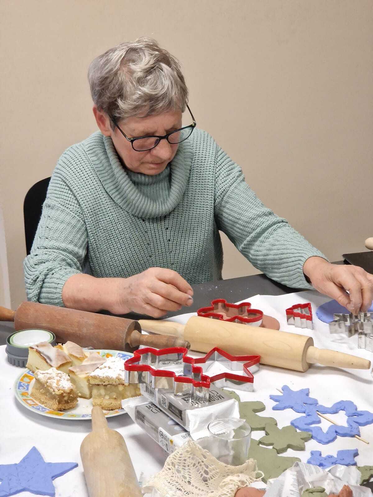 uczestniczka warsztatów przy stole tworząca ozdoby ceramiczne