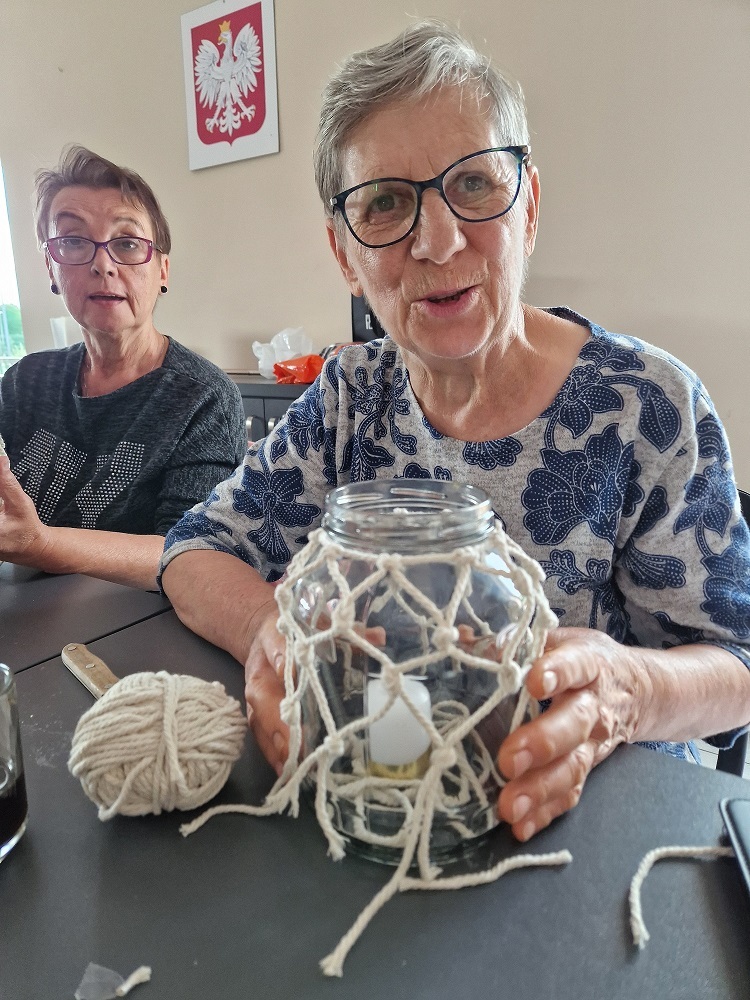 zdjęcie przedstawia uczestniczkę zajęć prezentującą przy stole lampion w trakcie tworzenia
