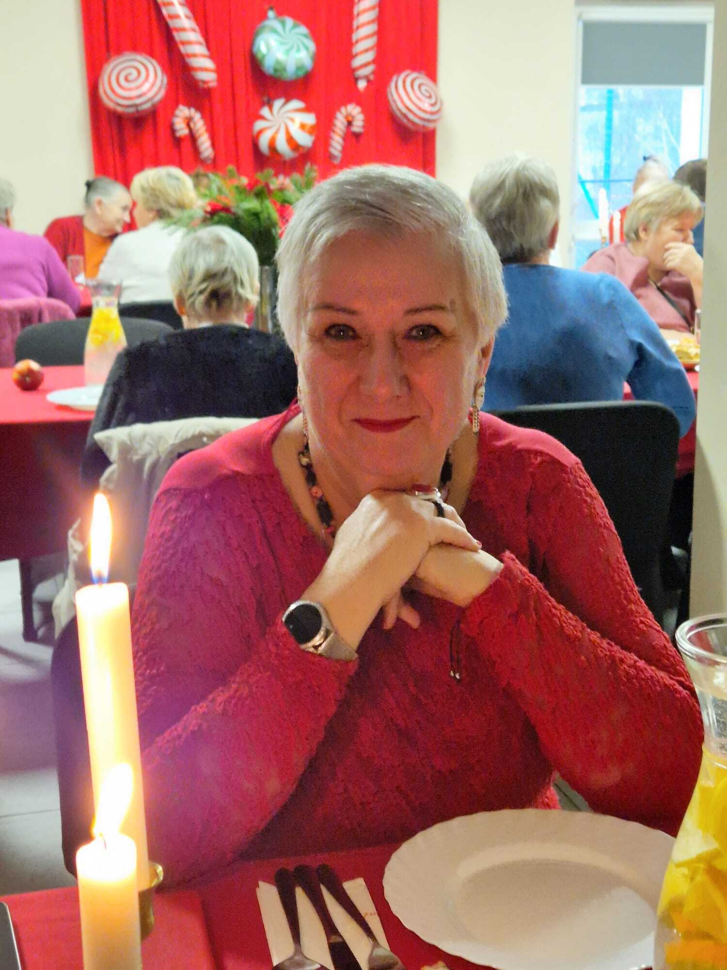 uczestniczka spotkania uśmiechnięta przy stosle mikołajkowym