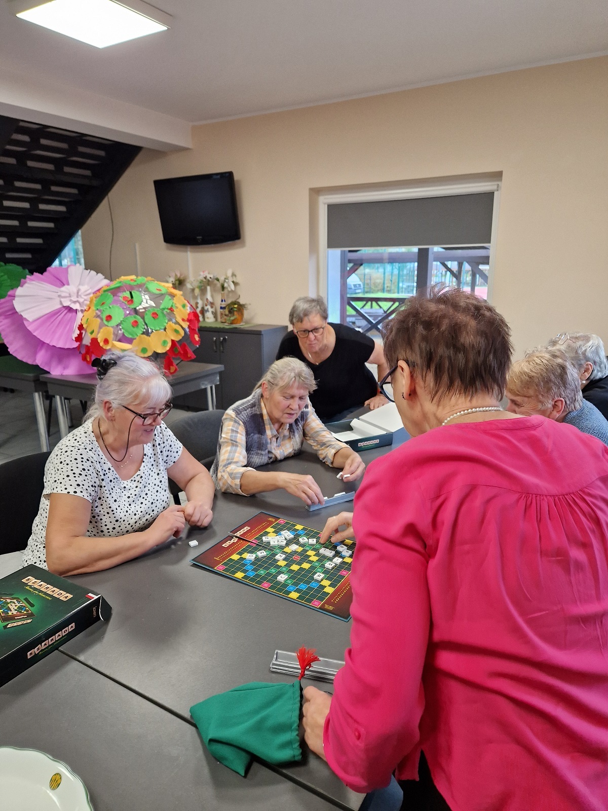 zdjęcie przedstawia kilka uczestniczek spotkania podczas gry w planszówkę
