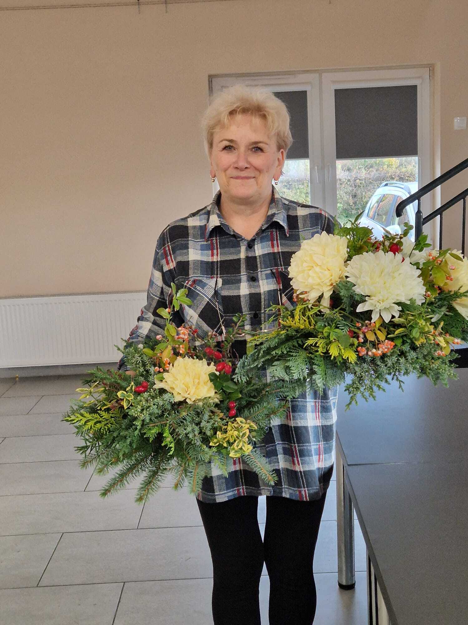 uczestniczka warsztatów prezentująca w dłoniach dwa gotowe stroiki