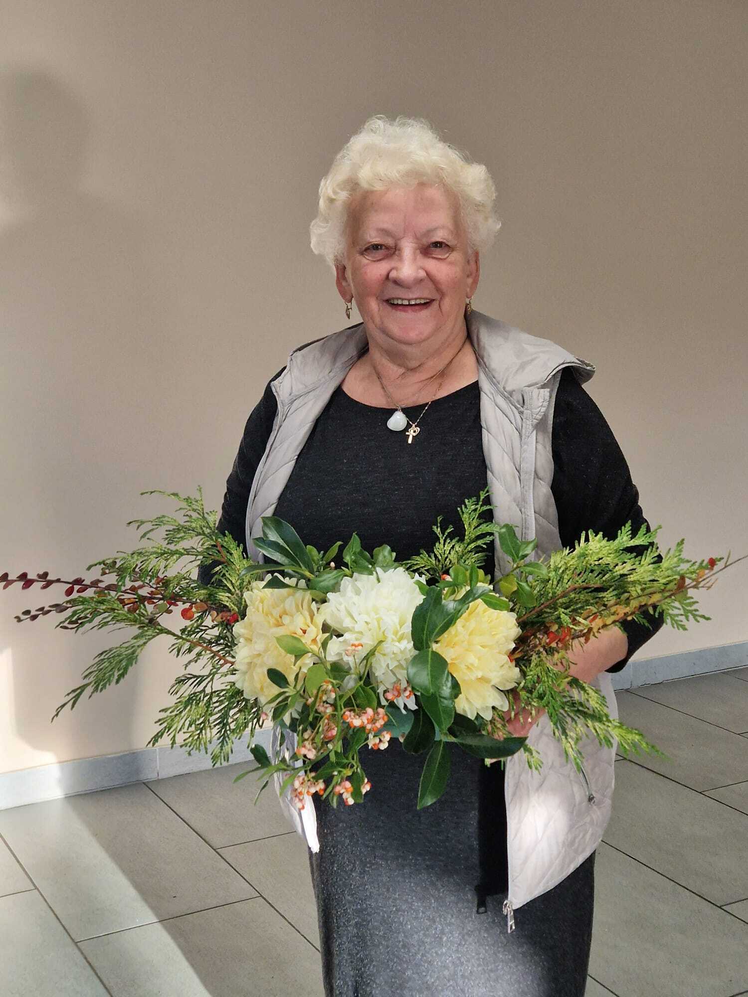 uczestniczka warsztatów prezentująca w dłoniach gotowy stroik