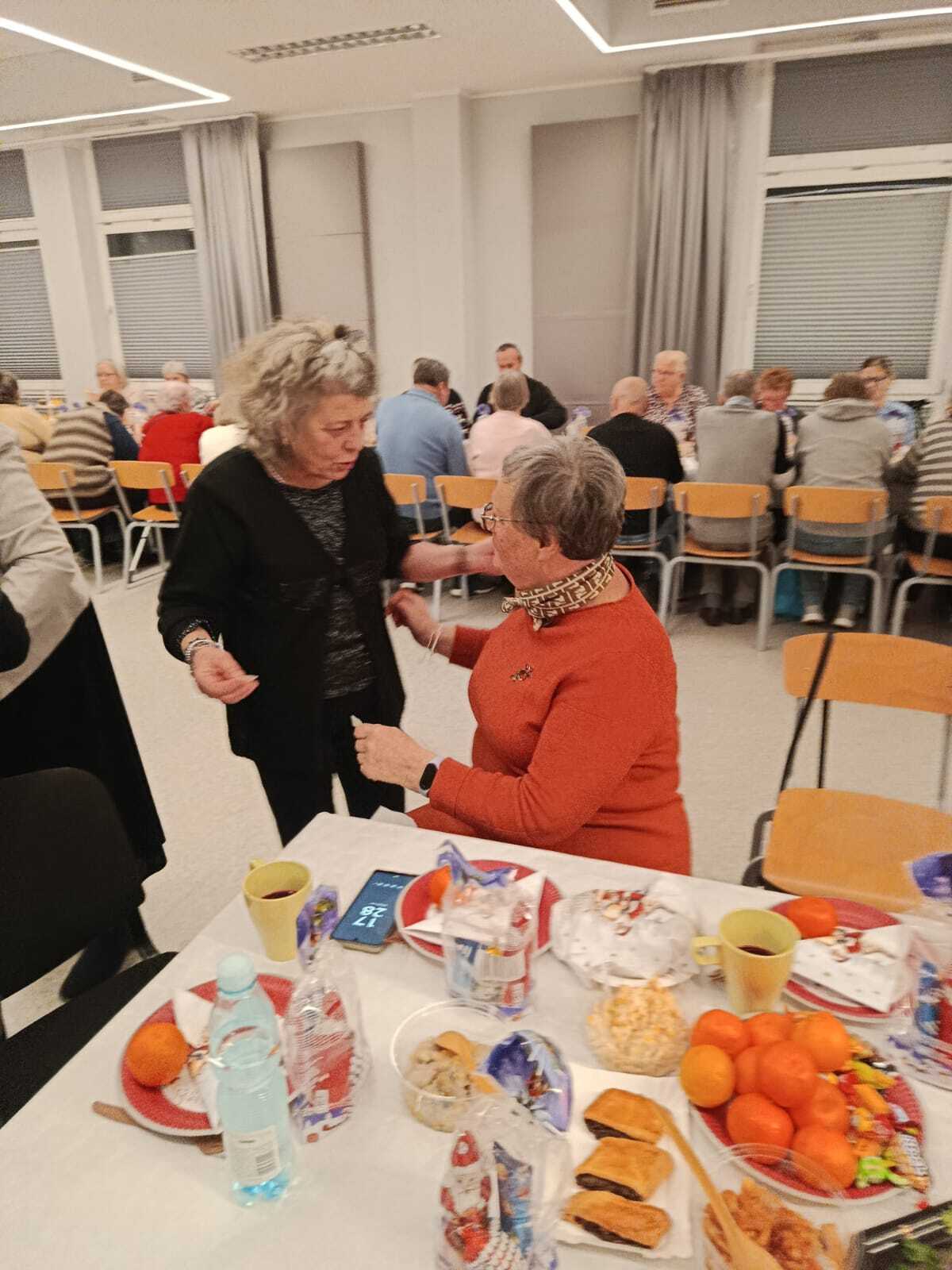 dwie uczestniczki spotkania składajace sobie życzenia świąteczne