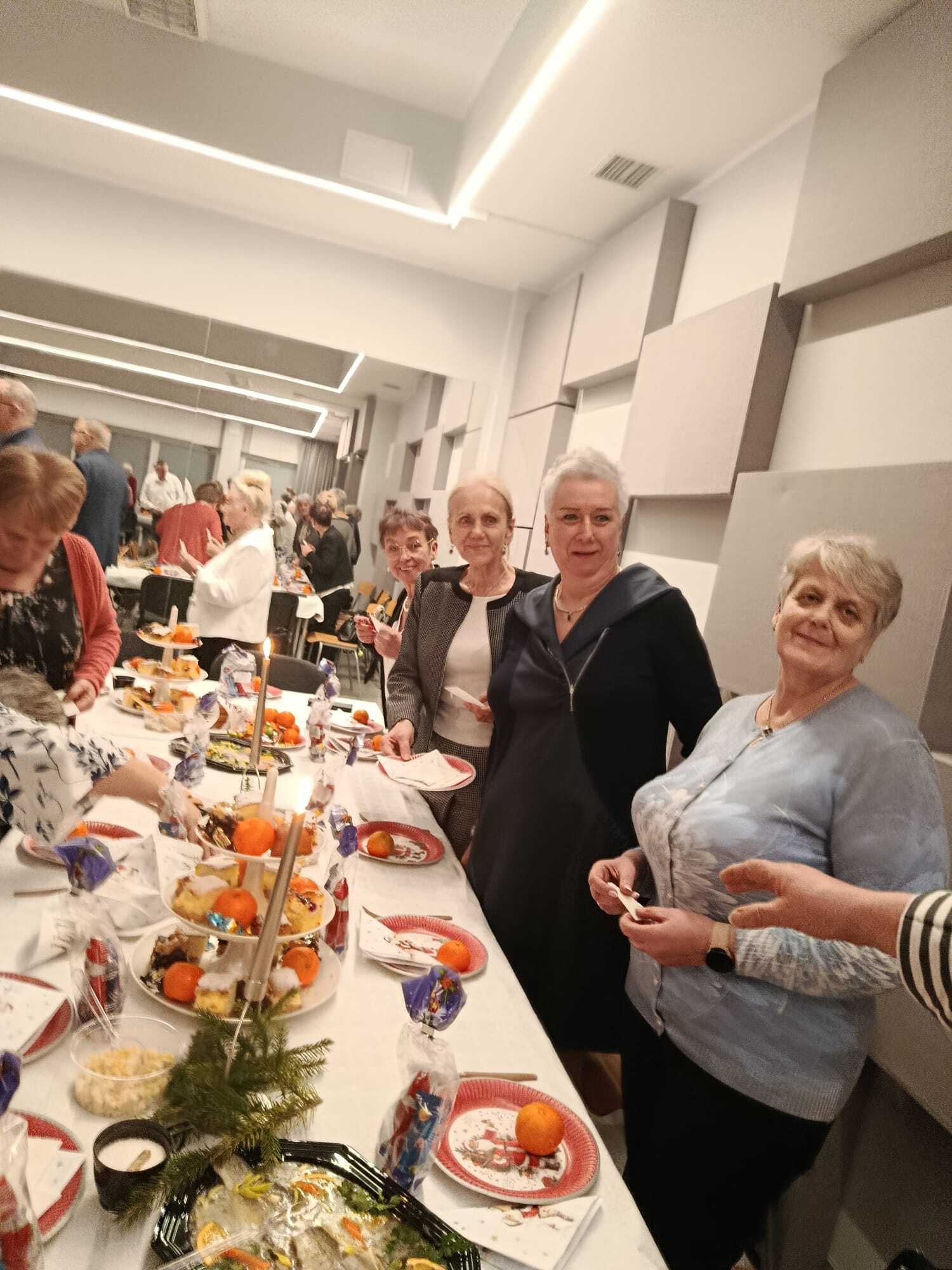 cztery uczestniczki spotkania stojące przy stole wigilijnym