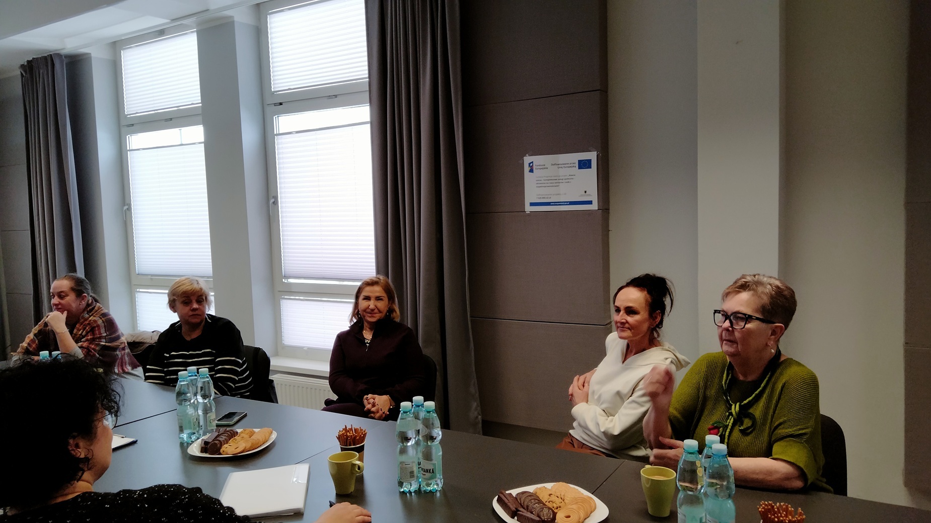 pięć uczestniczek spotkania grupy wsparcia siedzące przy wspólnym stole