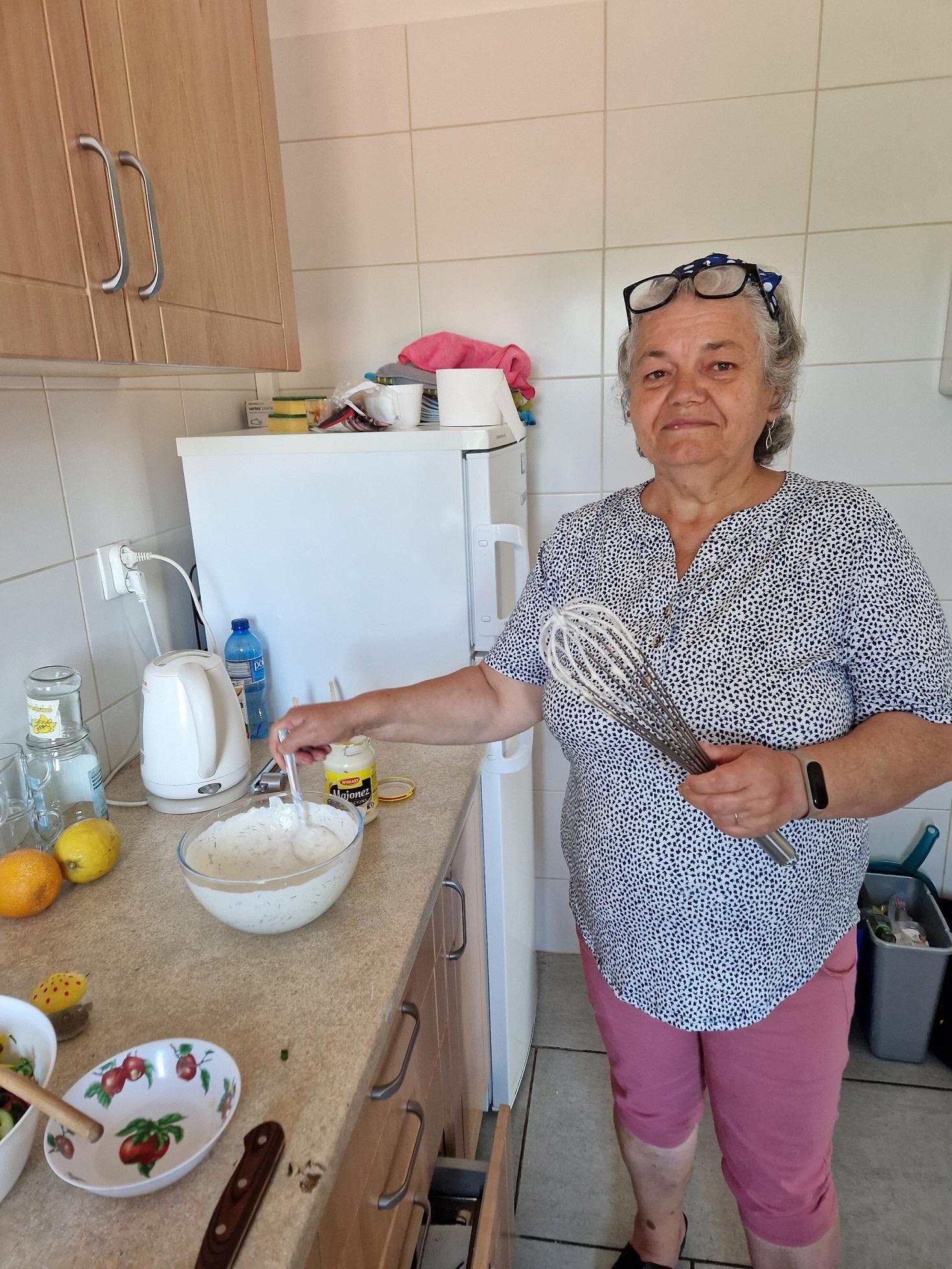 uczestniczka warsztatów przy blacie kuchennym z rózgą w dłoni