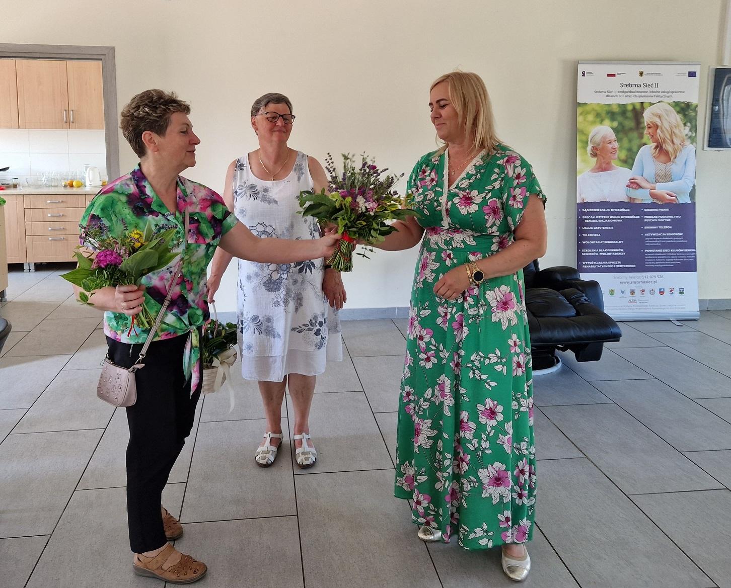 uczestyniczki warsztatów przekazujące w podziękowaniu bukiet kwiatów dla kierownika ośrodka pomocy społecznej w kobylnicy