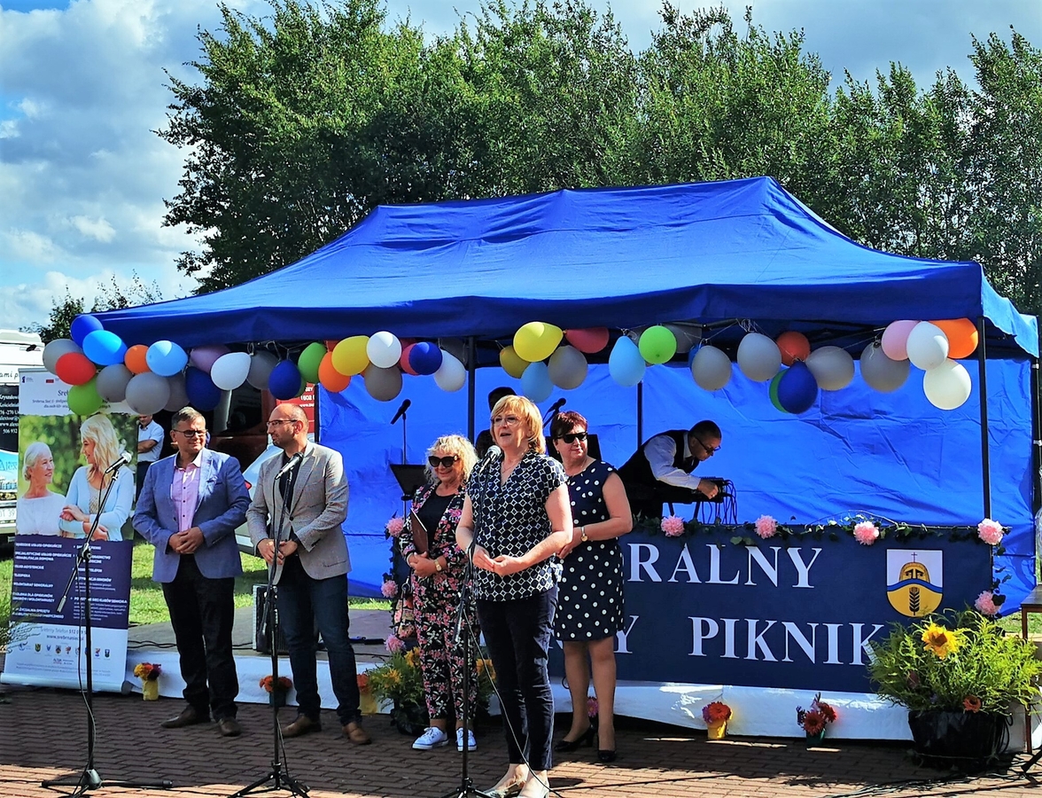 przemówienie prowadzących piknik senioralny, w tle niebieski namiot