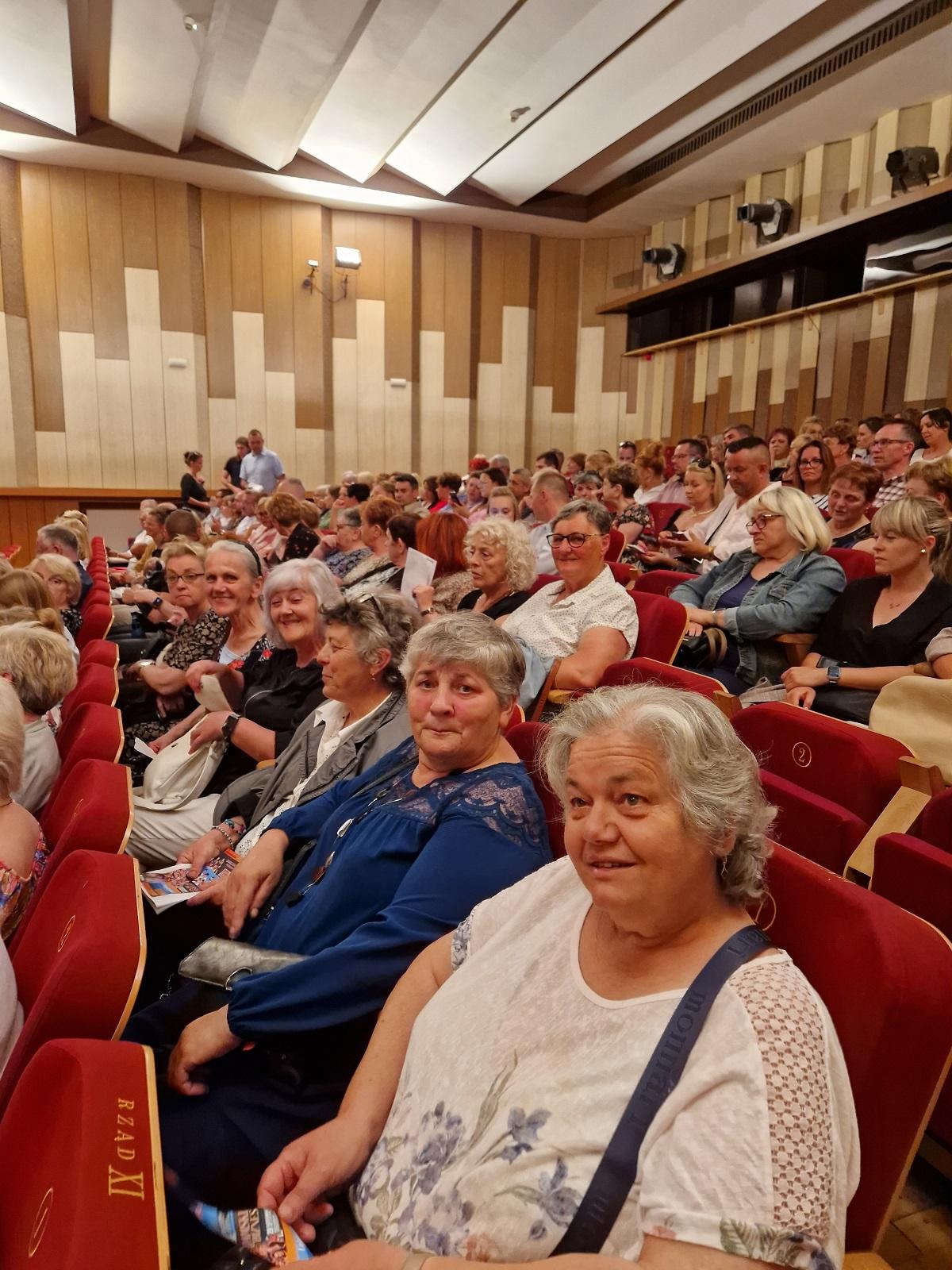uczestniczki wycieczki w fotelach sali filharmonii słupskiej w oczekiwaniu na spektakl