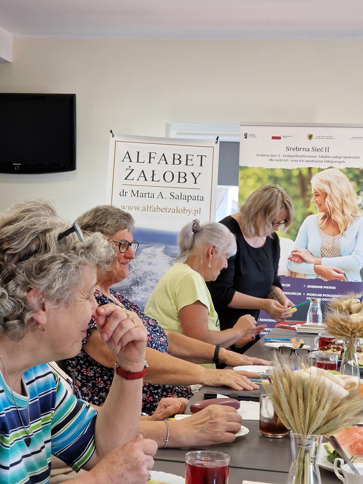 uczestniczki spotkania wraz z prowadzącą przy wspólnym stole