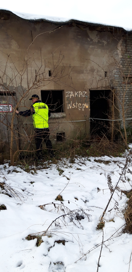 Strażnik gminny przed wejściem do budynku niemieszkalnego